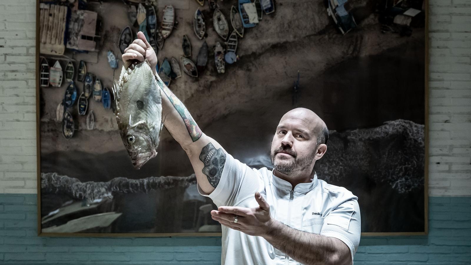 El cocinero Tomás de la Paz con un gallo de San Pedro en la sala del restaurante Yakumanka.