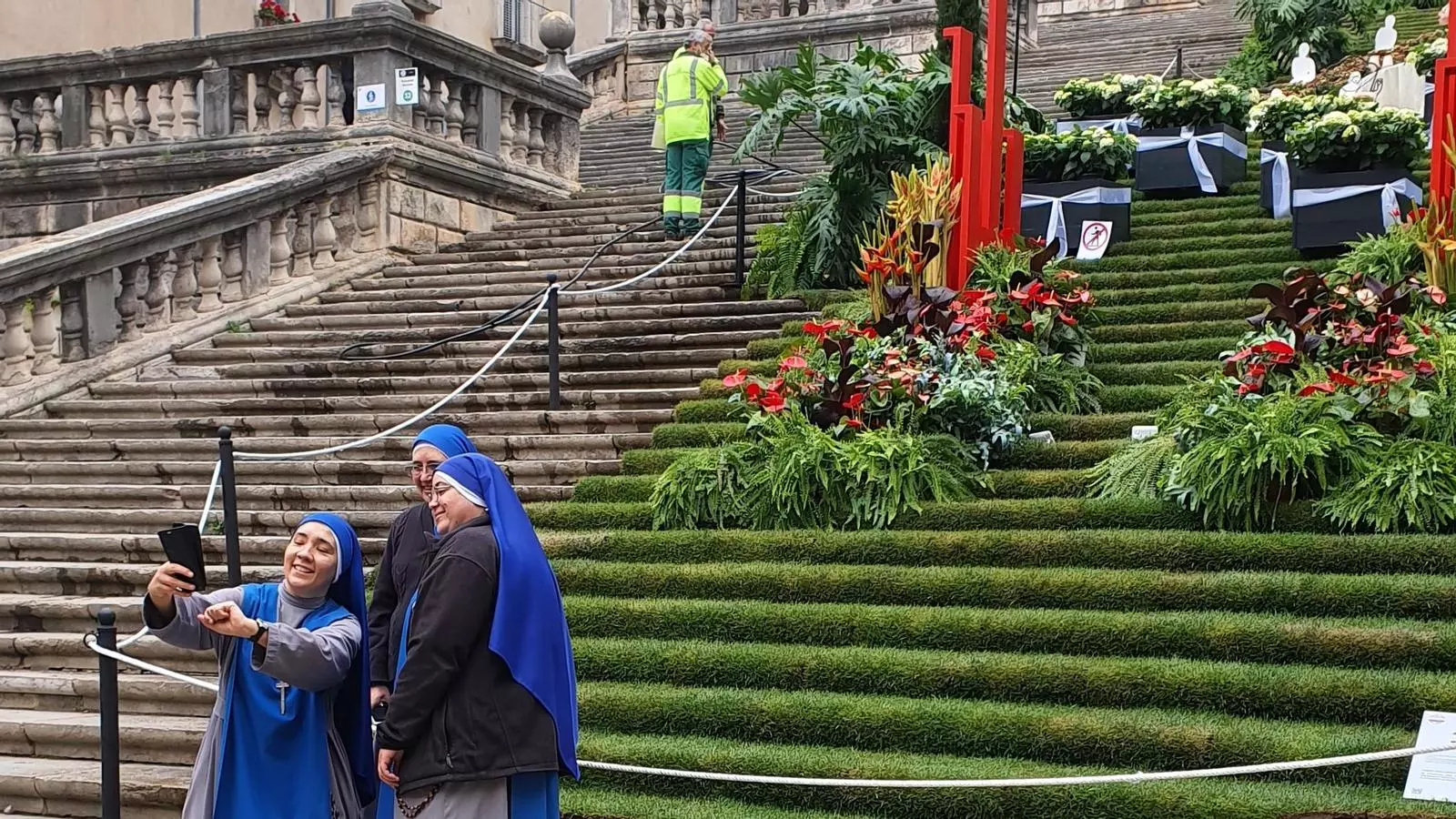 Dues monges es retraten davant d'una instal·lació a les escales de la catedral de Girona.