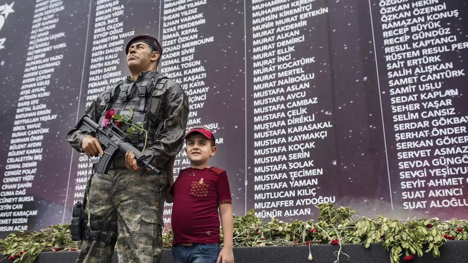 Un nen es fotografia al memorial dels màrtirs del cop d’Estat