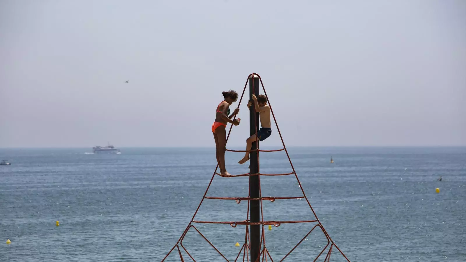Infants juguen a la Barceloneta durant l'onada de calor.