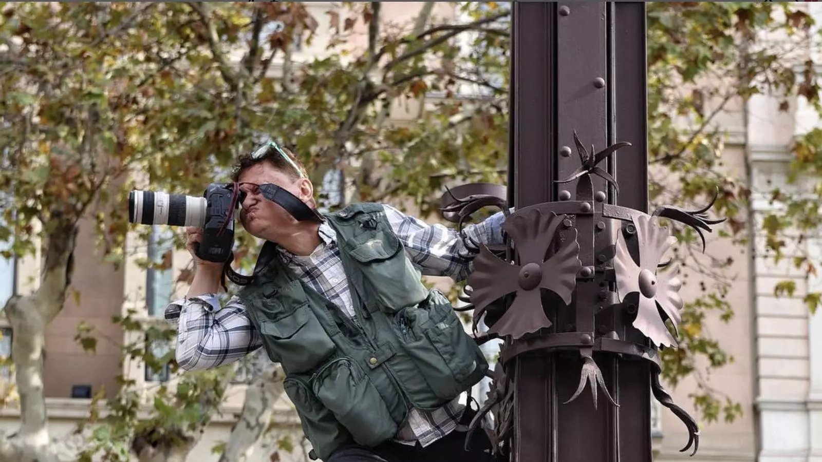 El foto periodista Jordi Roviralta a sobre d'un fanal de Passeig de Gràcia cobrint una manifestació