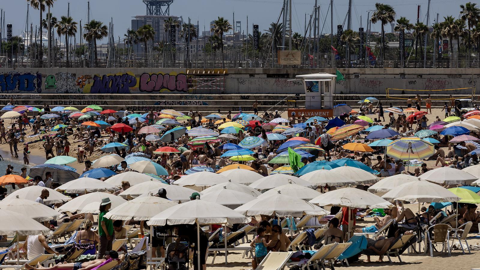 La playa de Bogatell, en Barcelona, hoy al mediodía, llena de gente