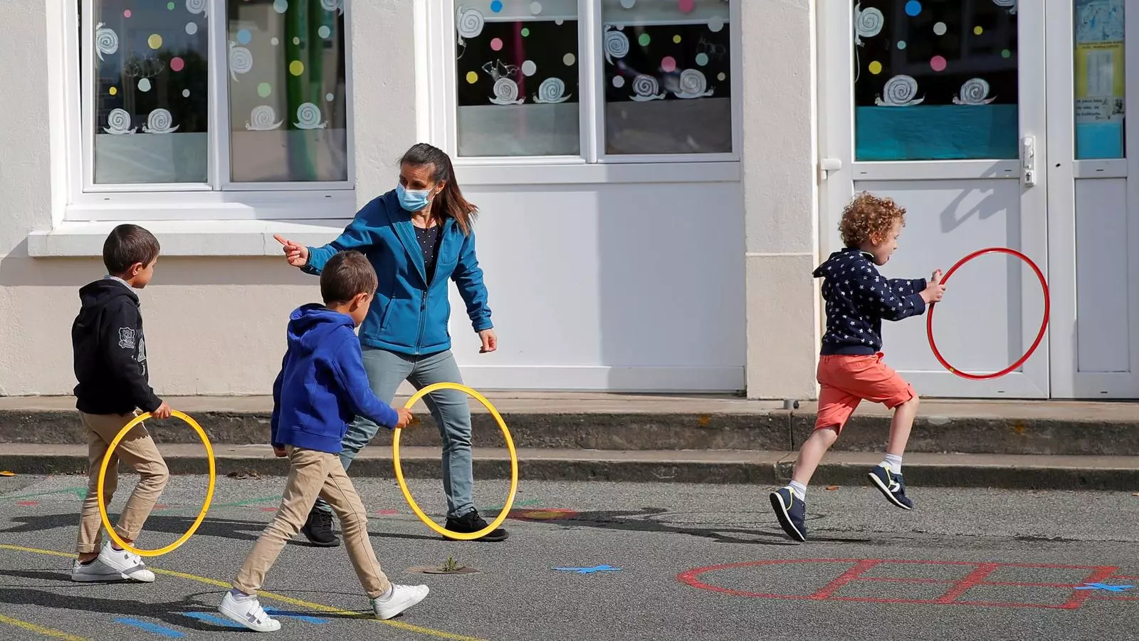 Niños en el patio de una escuela durante la pandemia.
