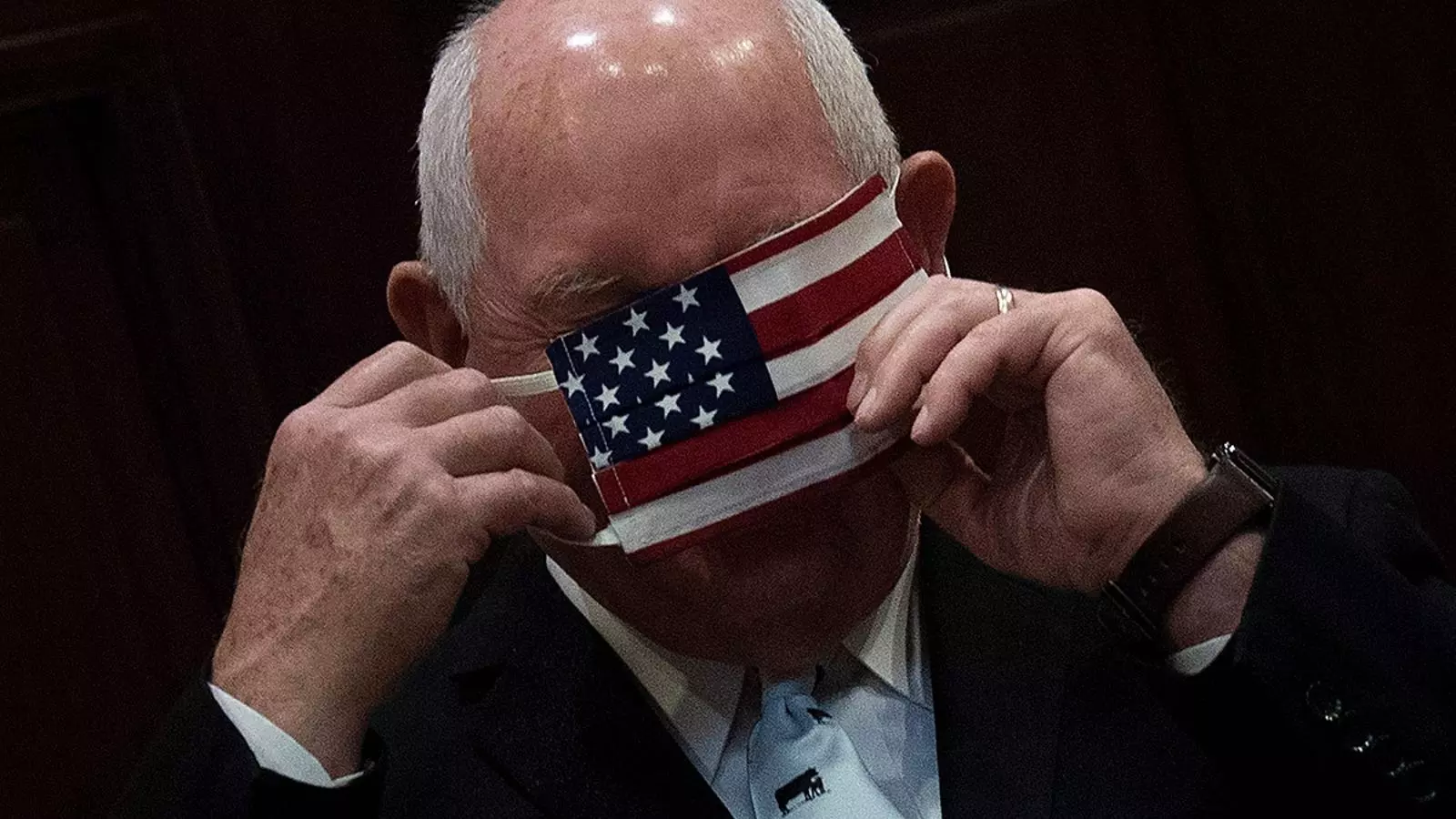 El secretari d'agricultura dels Estats Units, Sonny Perdue, posant-se una mascareta amb la bandera americana durant una recepció a la Casa Blanca.