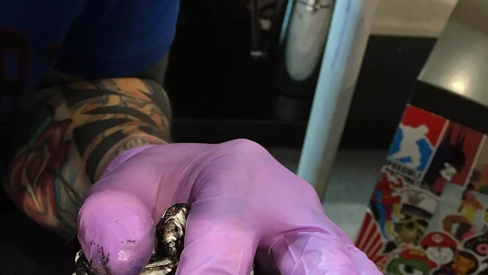 Un tatuador fent el tatuatge del símbol de Manchester