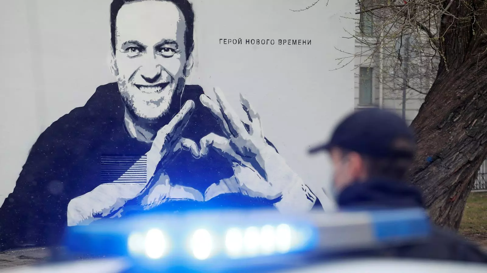 Un policia davant un grafiti a favor de Navalni a Sant Petersburg
