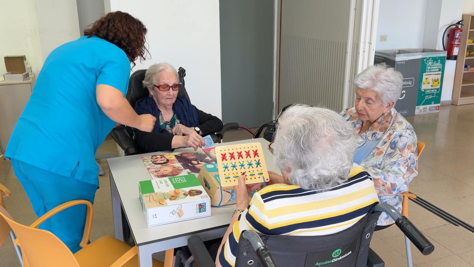 Una auxiliar atendiendo a usuarias de una residencia del barrio barcelonés de Gràcia.