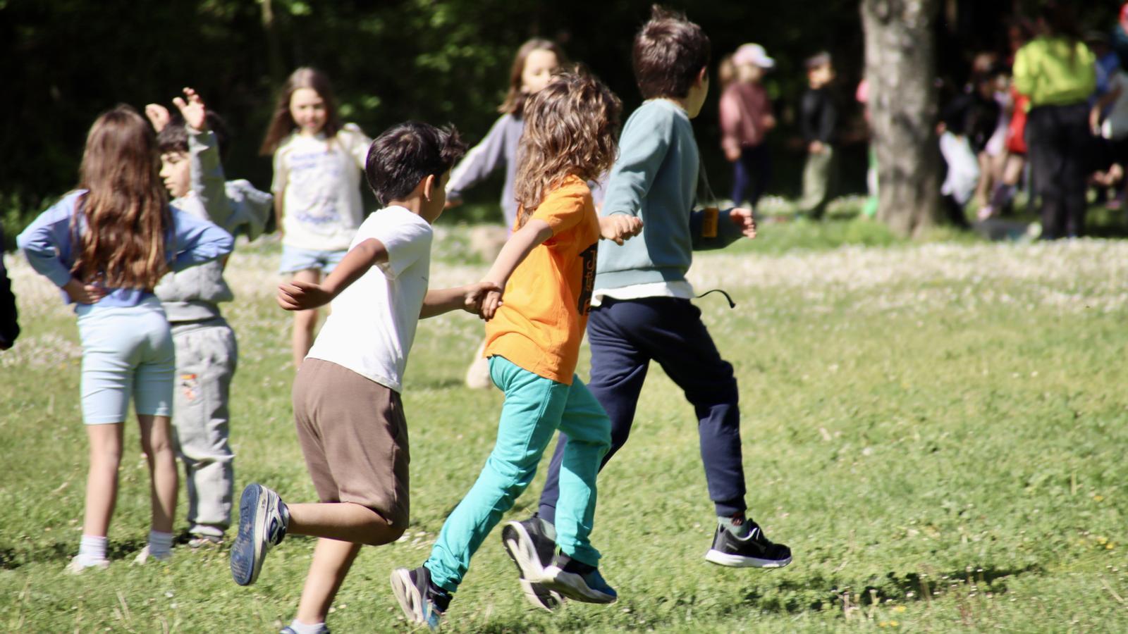 Boys and girls play in a meadow at the Mas Banyeres colony house, in Centelles.
