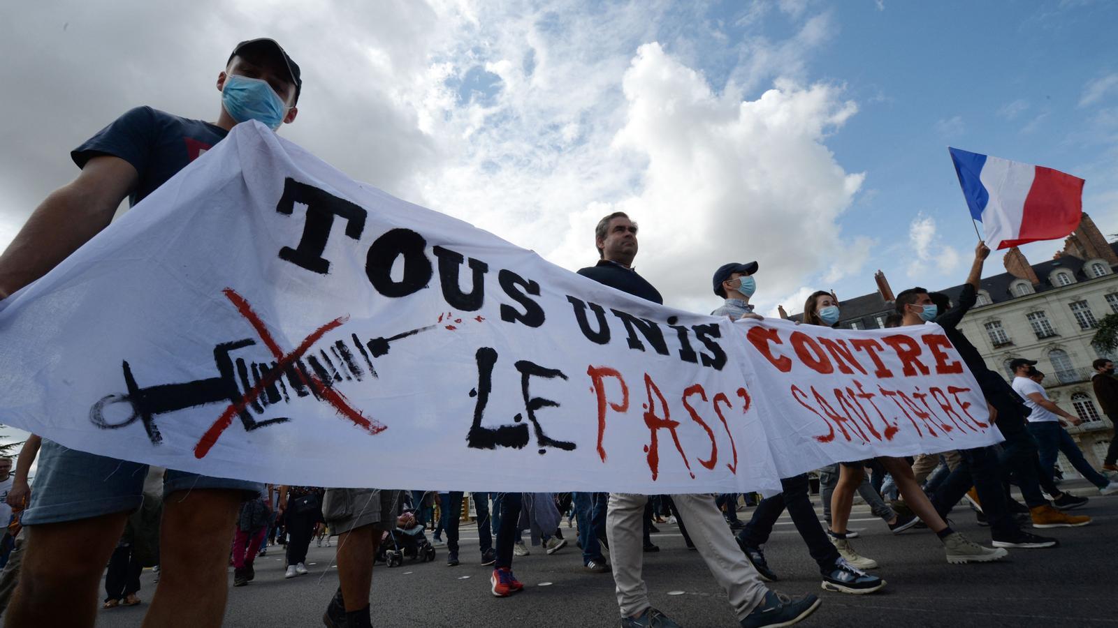 Un grupo de manifestantes franceses muestran a Nantes una pancarta en que  dice: "tots unidos contra el certificado sanitario".