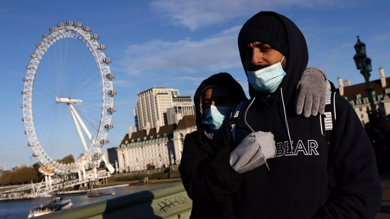 Una parella passeja pel pont de Westminster, a Londres, amb la mascareta posada, després que aquest dissabte s'anunciessin noves mesures a causa de l'arribada de la nova variant de covid, anomenada òmicron