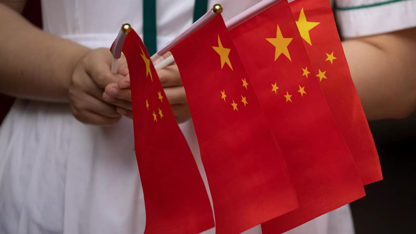 Una estudiant amb banderes xineses durant una cerimònia escolar a Hong Kong.