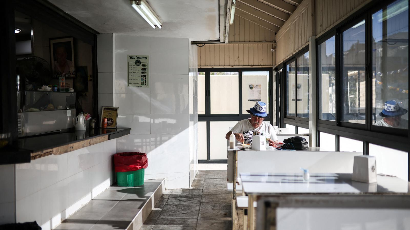 Un hombre come en un bar en Kiryat Shmona, al norte de Israel.