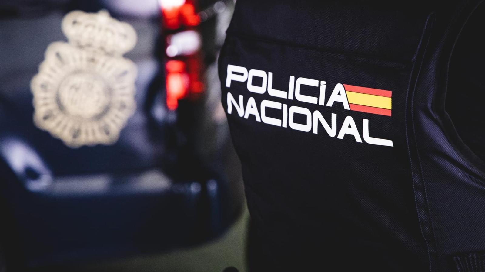 Un agent de la Policia Nacional d'esquenes.