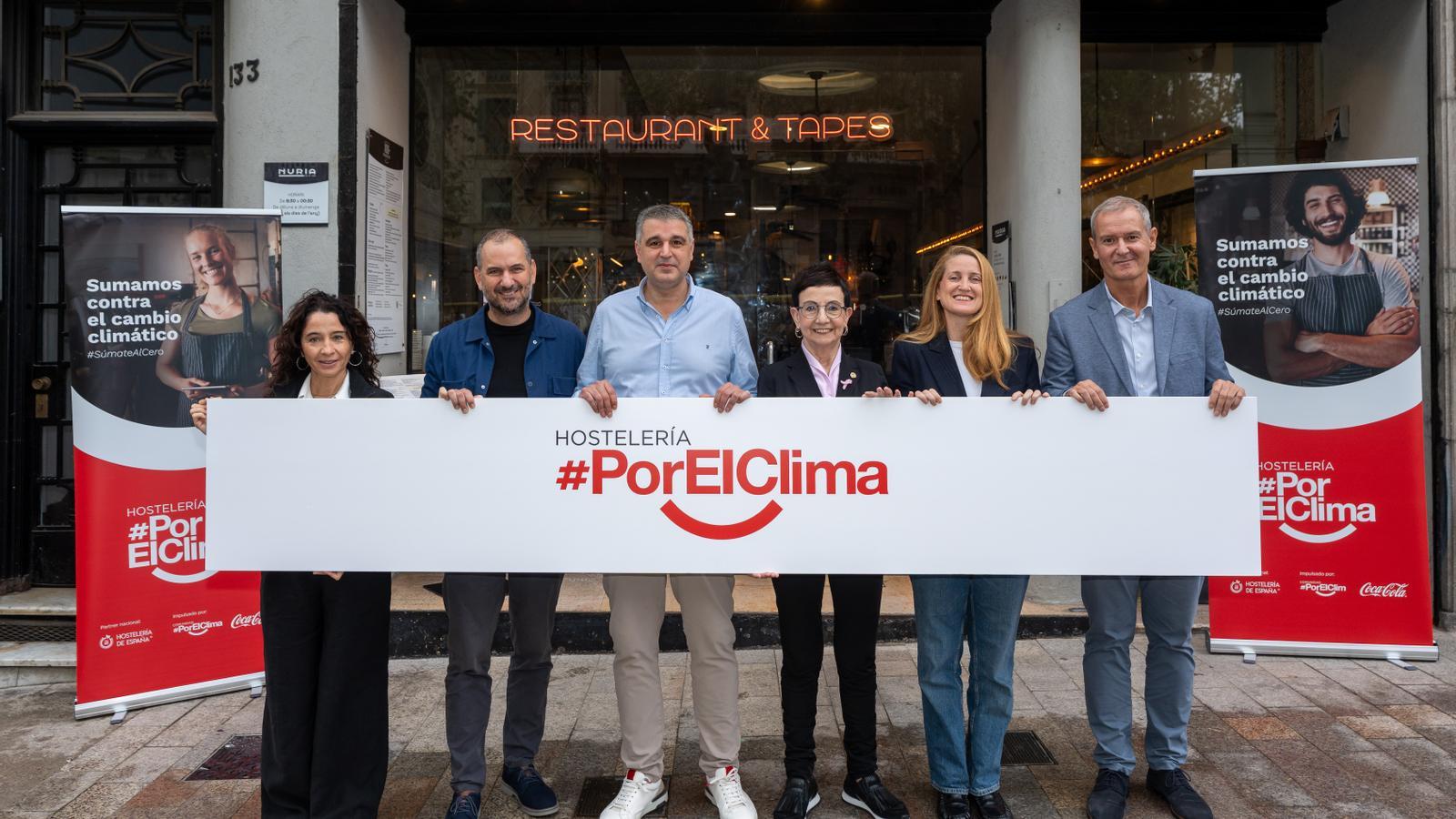 Foto con el cartel de la campaña delante del restaurante Núria