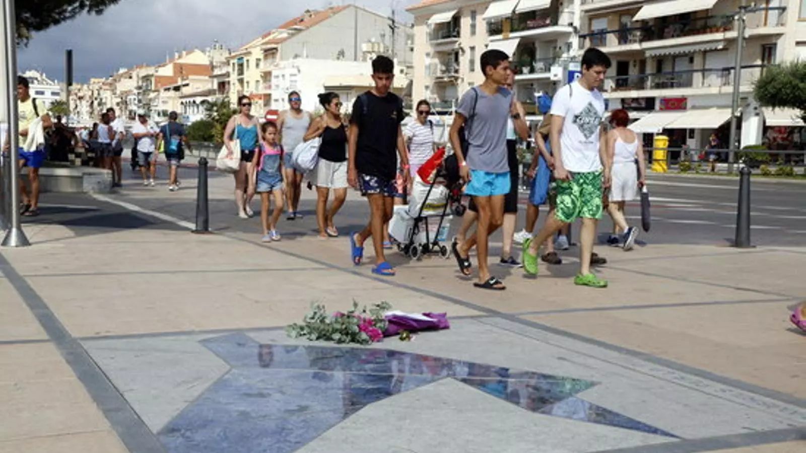 Un grup de joves passen per davant del record a les víctimes de Cambrils