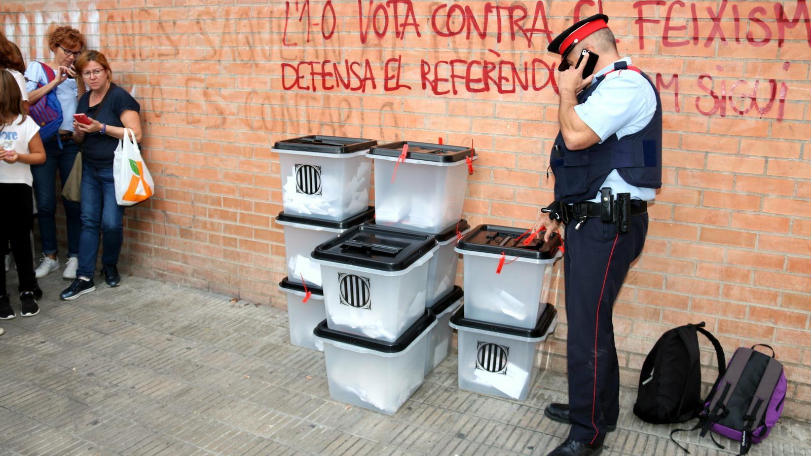A Mossos d'Esquadra agent inspecting the ten ballot boxes at the Josep Lladonosa institute in Lleida
