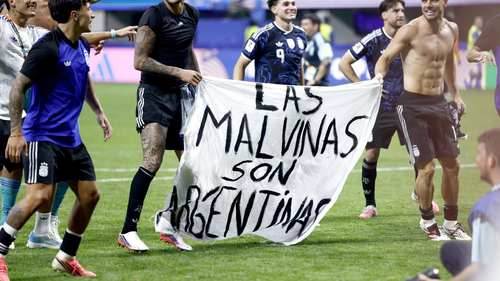 Argentine players hold a banner proclaiming the Malvinas Islands as Argentine, after the semifinal against England