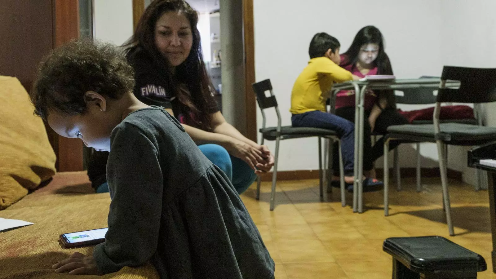 La Julia, amb la seva filla Johany de 16 mesos en primer pla, i la Nuria i l'Isaías al fons fent els deures
