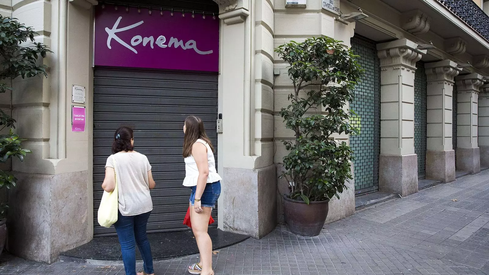 Dues noies observen la papereria Konema de la rambla de Catalunya de Barcelona tancada definitivament.