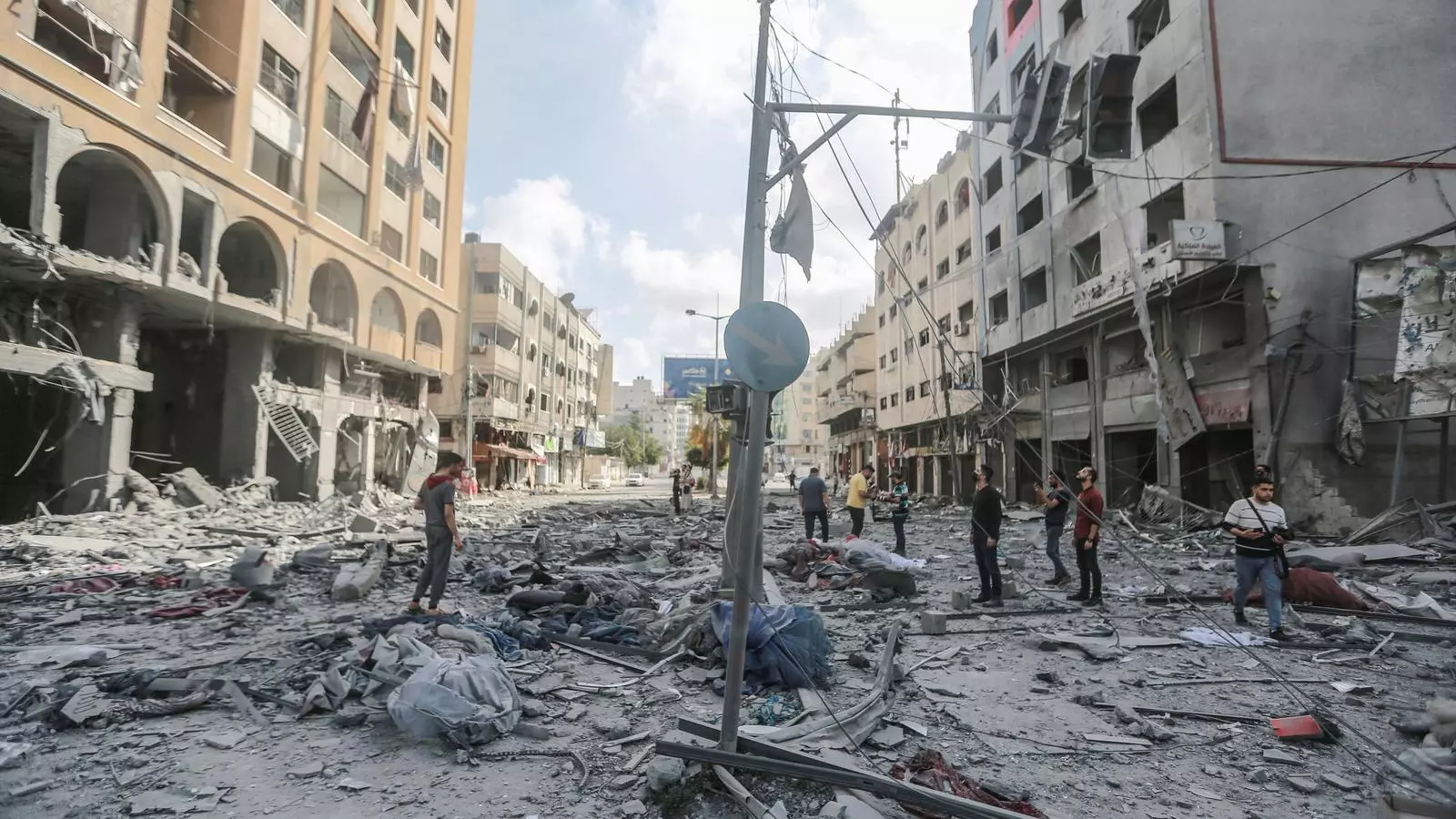 Los palestinos inspeccionan la zona de la torre Al-Jawhara gravemente dañada a la ciudad de Gaza después de ser atacada por ataques aéreos israelíes en medio del estallido de la violencia israelí-palestina