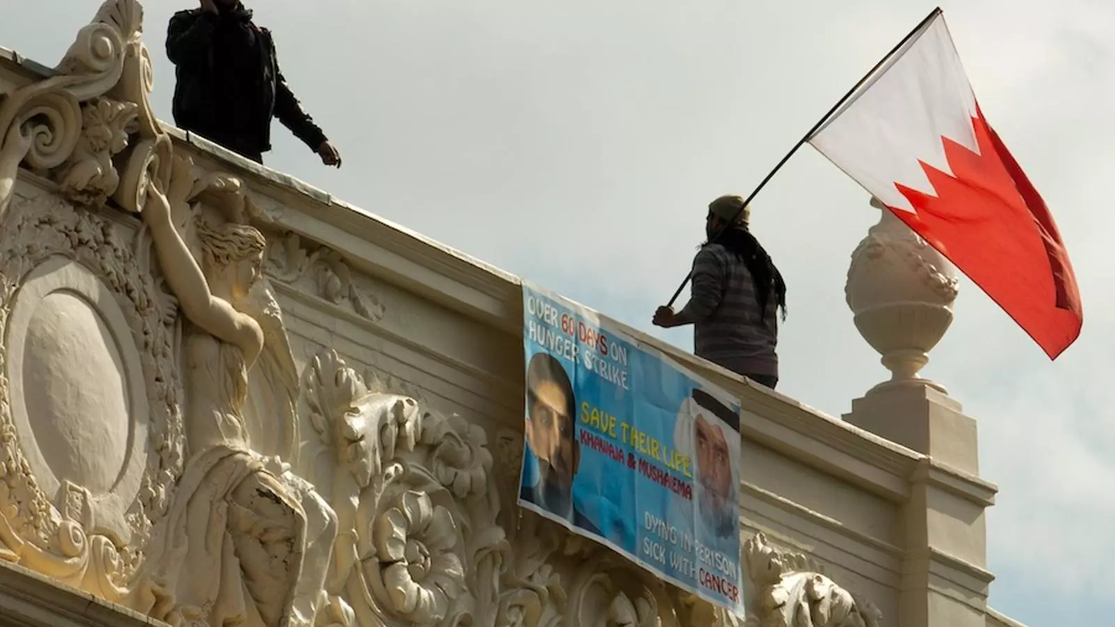 Un home ondeja una bandera bahrainiana a l'ambaixada del país a Londres aquest dilluns. / LEON NEAL / AFP