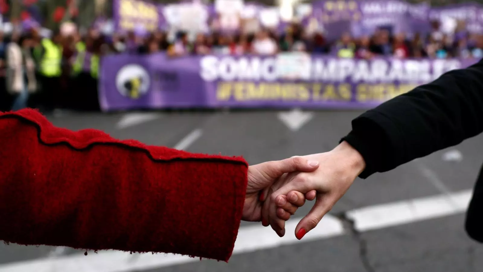 Dues dones agafant-se de la mà a la manifestació del 8 de març, Dia de la Dona, del 2019 a Madrid.
