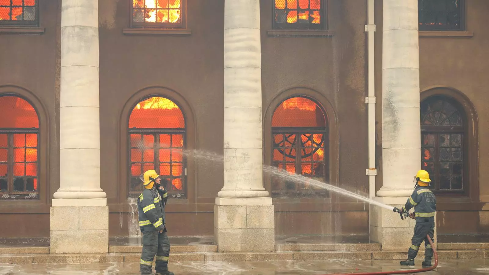 Los bomberos intentan apagar las llamas mientras la biblioteca de la Universidad de Cape Town crema, Soud-àfrica