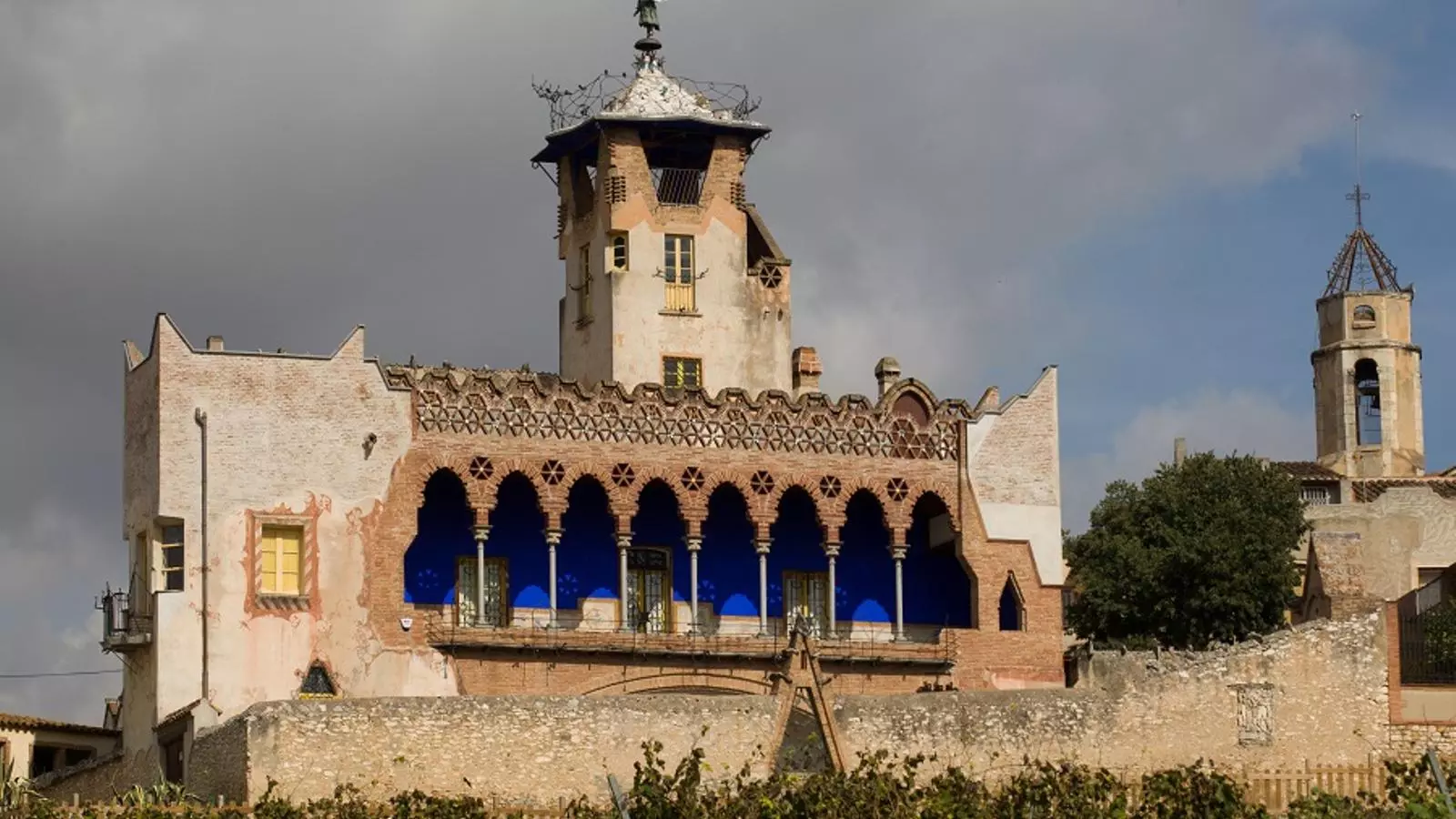 Vista de la façana sud de la Casa Bofarull. El maó de les arcades de la galeria contrasta amb la delicadesa dels set pilars que la sostenen