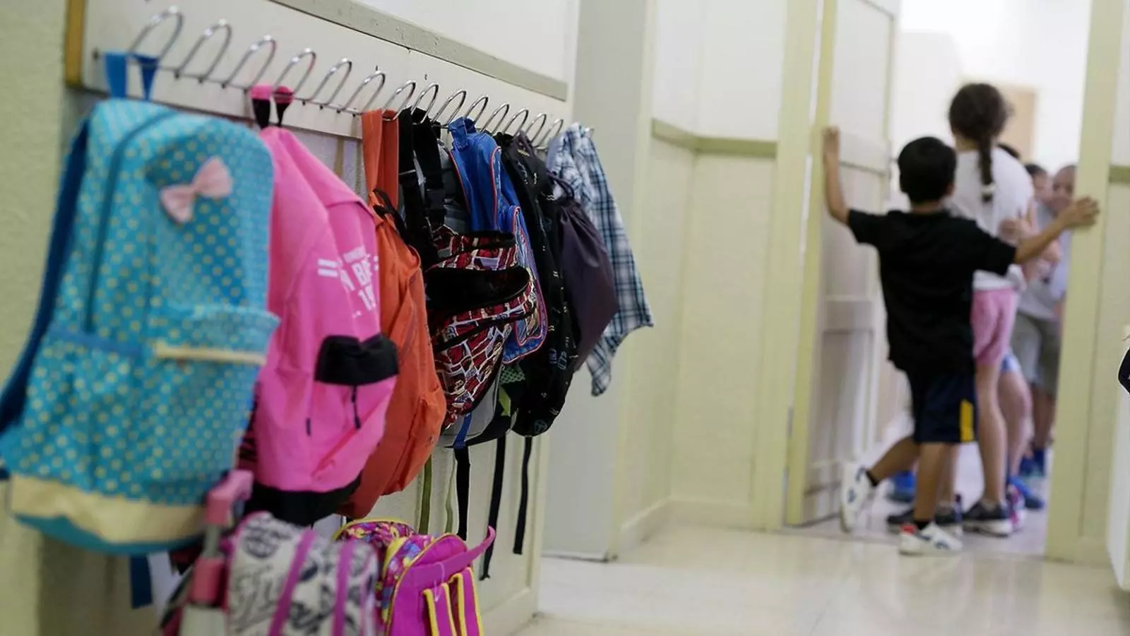 Some children enter a classroom in a school in Barcelona on the first day of the school year.