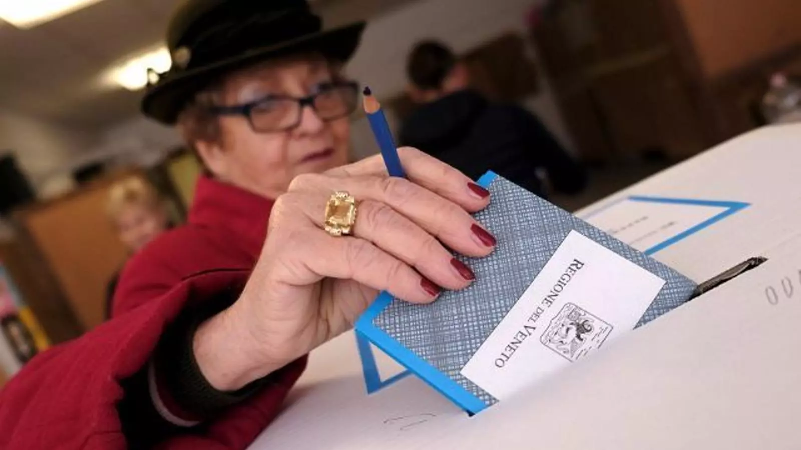Una dona introdueix el seu vot al referèndum, en un col·legi de Venècia.
