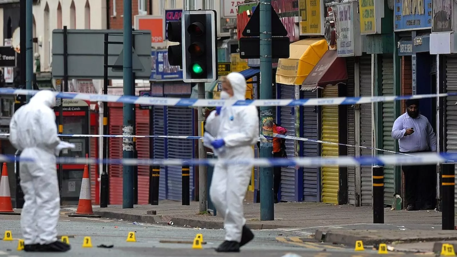 Agents de la policia anglesa recollint proves en un carrer de Birbimgham on hi ha hagut aldarulls / AFP