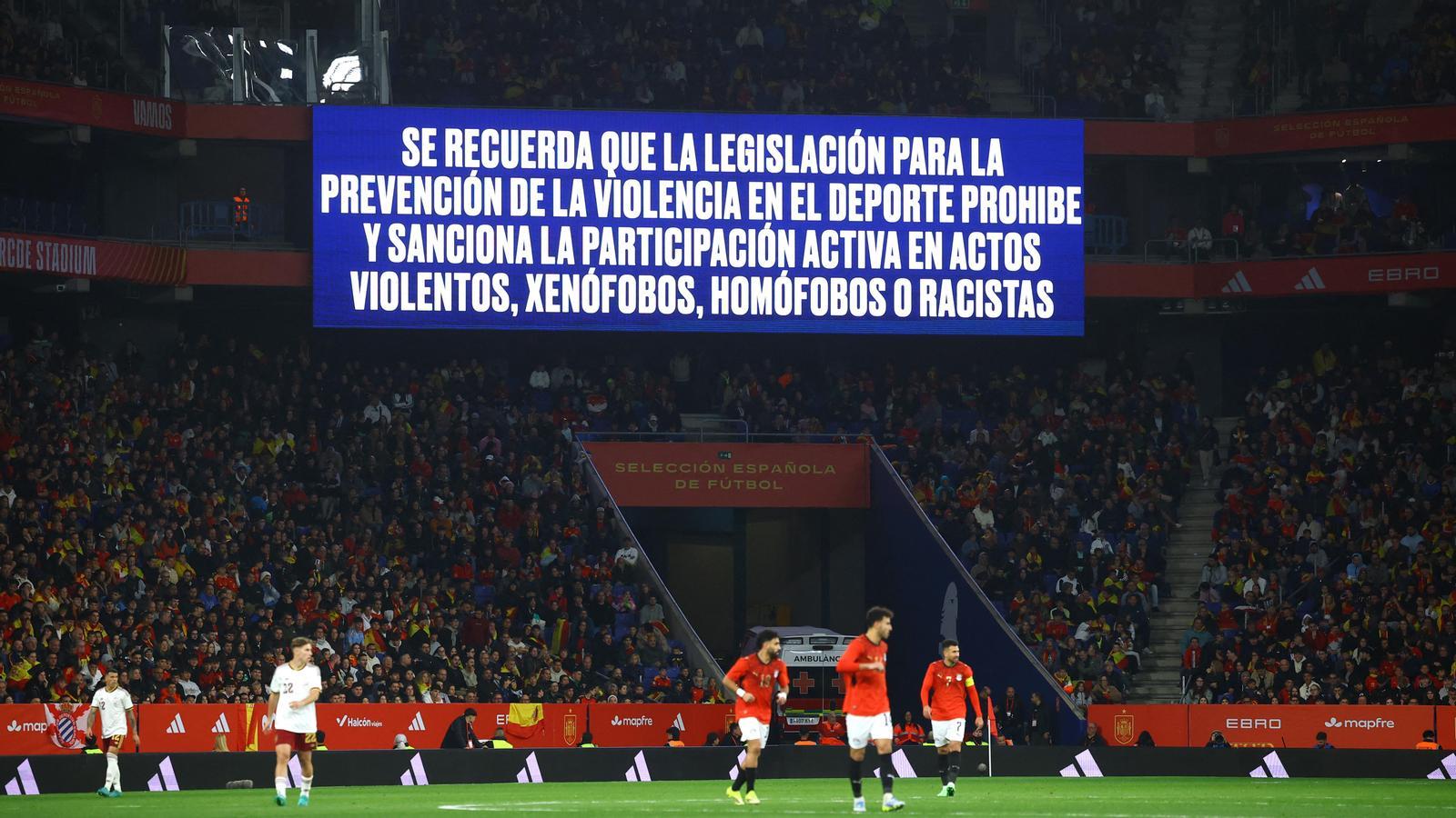 Una pantalla gigante muestra un mensaje antidiscriminación dentro del estadio durante el partido