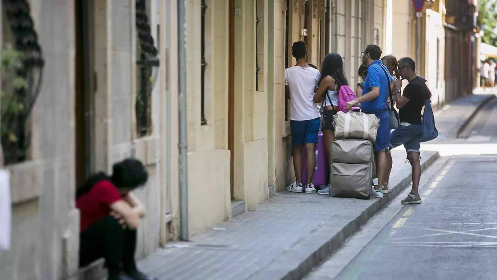 Un grup de turistes accedint a un dels pisos turístics que hi ha al barri de la Barceloneta en una imatge d’arxiu.