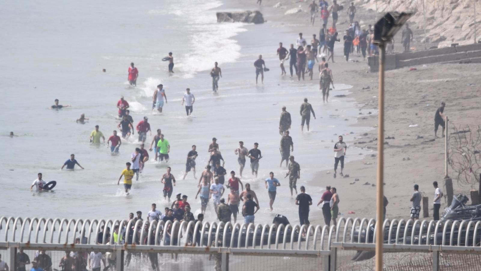Several migrant people cross the border of Ceuta in an archive image.