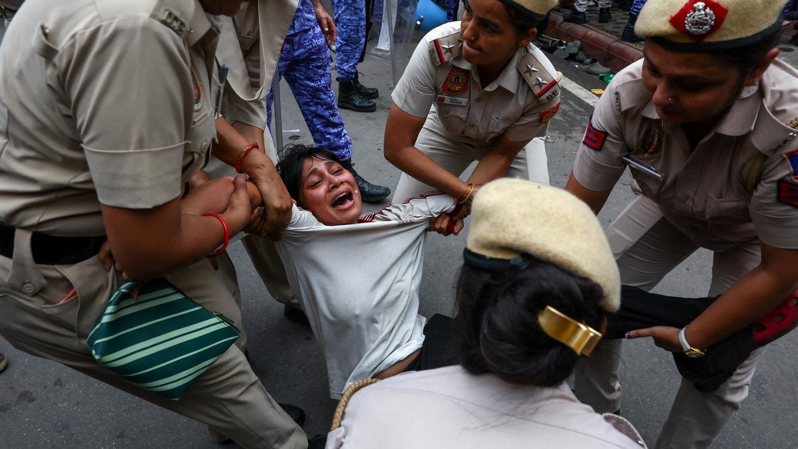 Agentes de policía cogen a una manifestante durante las protestas impulsadas por el Partido de las Cucarachas, en Nueva Delhi.