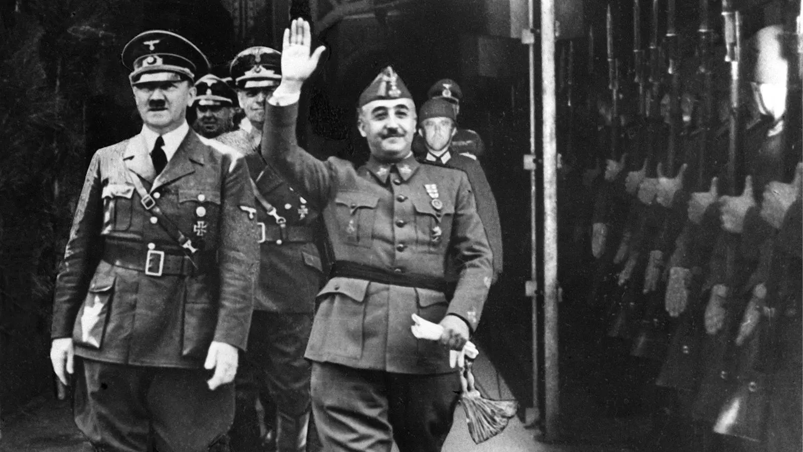 Francisco Franco amb Adolf Hitler. Tots dos dictadors van passar revista a les tropes que apareixen a la imatge i van aixecar el braç com salutació, però les figures de Franco i de Hitler van ser preses d'un altre acte anterior i enganxades sobre l'original d'Hendaia, probablement per realçar la seva imatge.
