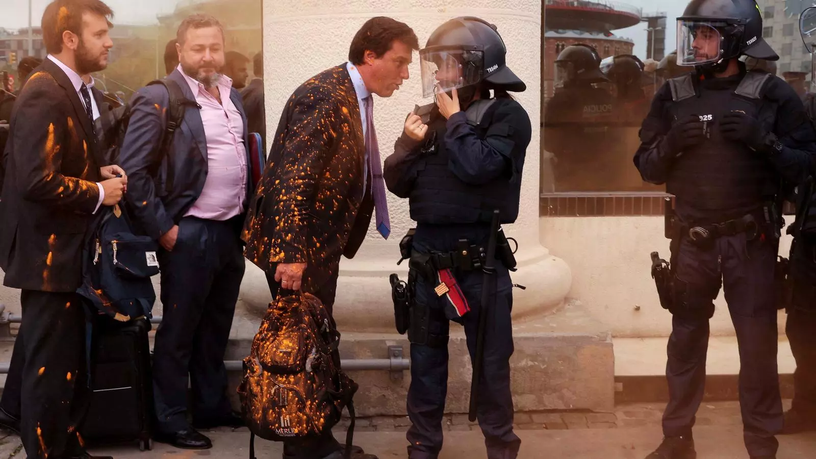 Treballadors d'empreses immobiliàries que participen a la fira immobiliària The District, parlen amb la policia després que els activistes els llancessin pols de colors durant una protesta per denunciar la crisi de l'habitatge i els desnonaments, a Barcelona, el 19 d'octubre de 2022.