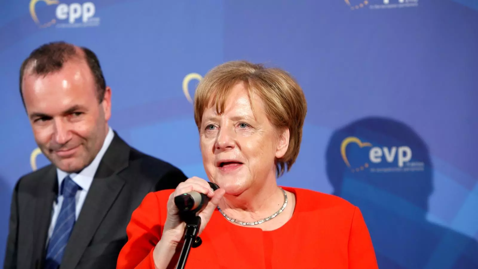Weber observa Merkel, en un acte del Partit Popular Europeu, en una imatge del mes de juny