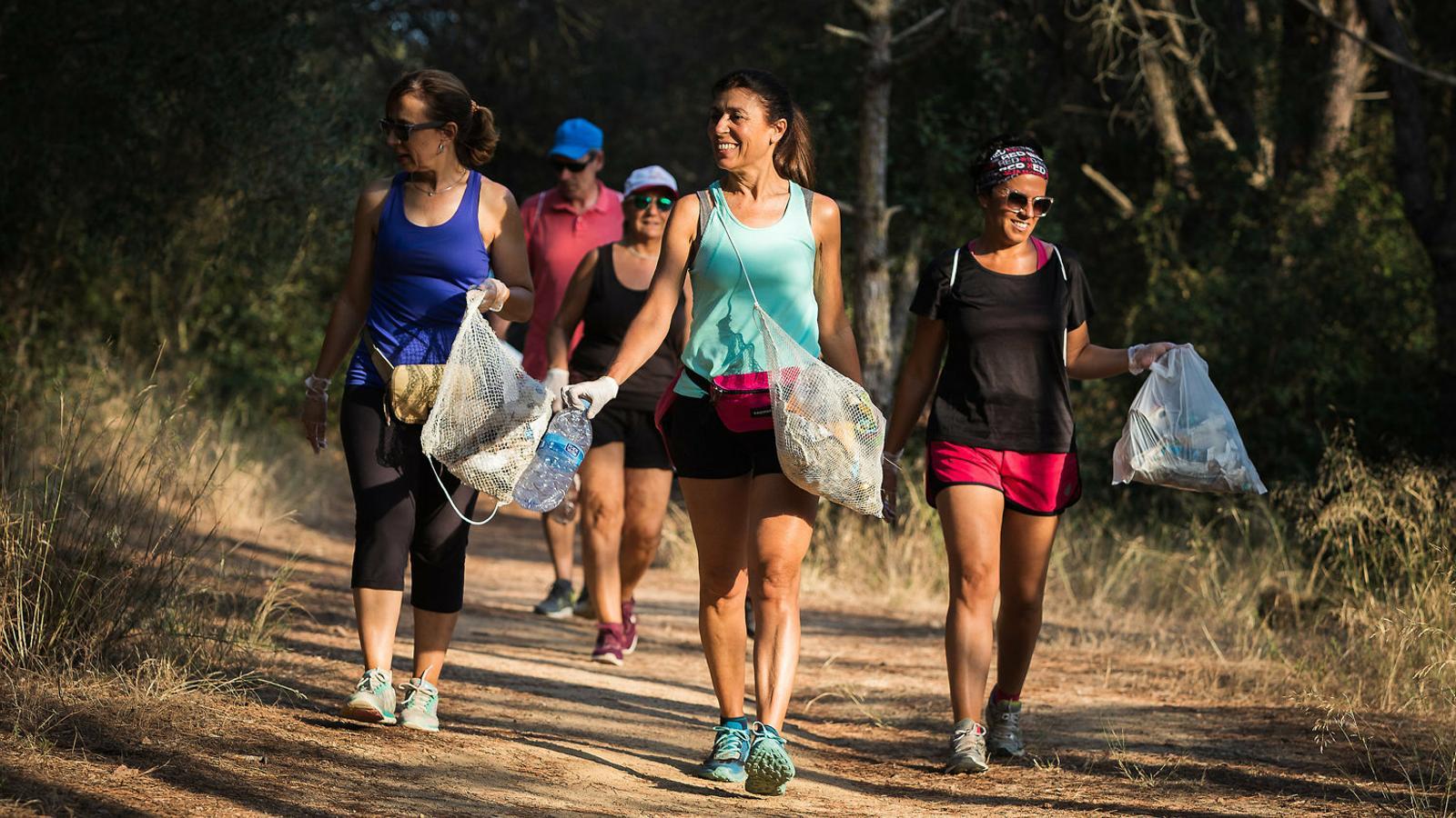 La Teresa Ferrés (de blau) i la seva germana Carme (de negre, a la dreta), en una sortida de plogging fa uns dies a Palamós. Algunes corredores recullen la brossa amb bosses fetes de xarxa de pescar. A baix, la Teresa recollint brossa a prop de la benzinera.