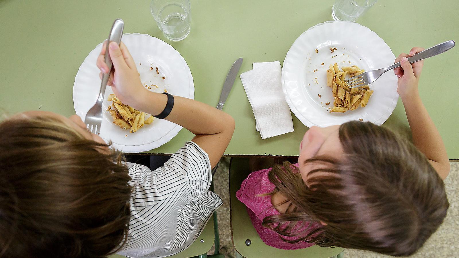 Two students eating in a school cafeteria in Girona.