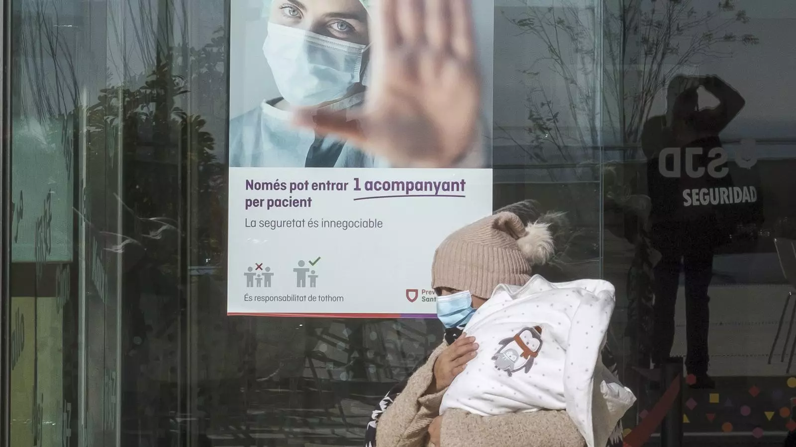 Una dona surt amb el seu nadó aquest dissabte del servei d'urgències pediàtriques de l'Hospital Sant Joan de Déu de Barcelona