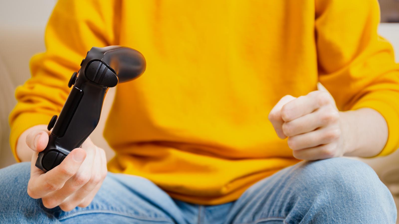 An angry teenager holds a console controller.