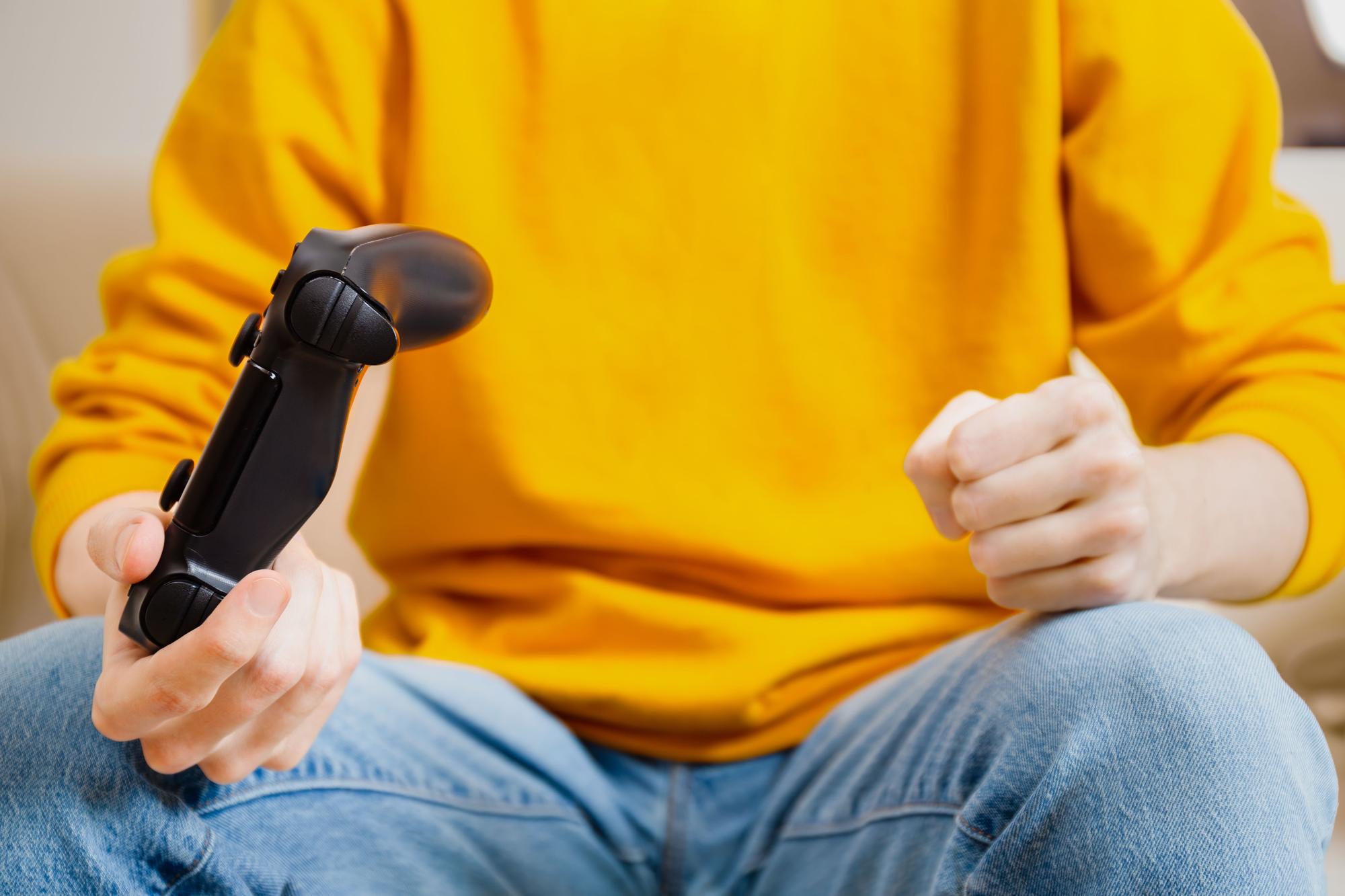 Un adolescent, enfadat, subjecta un comandament de consola.