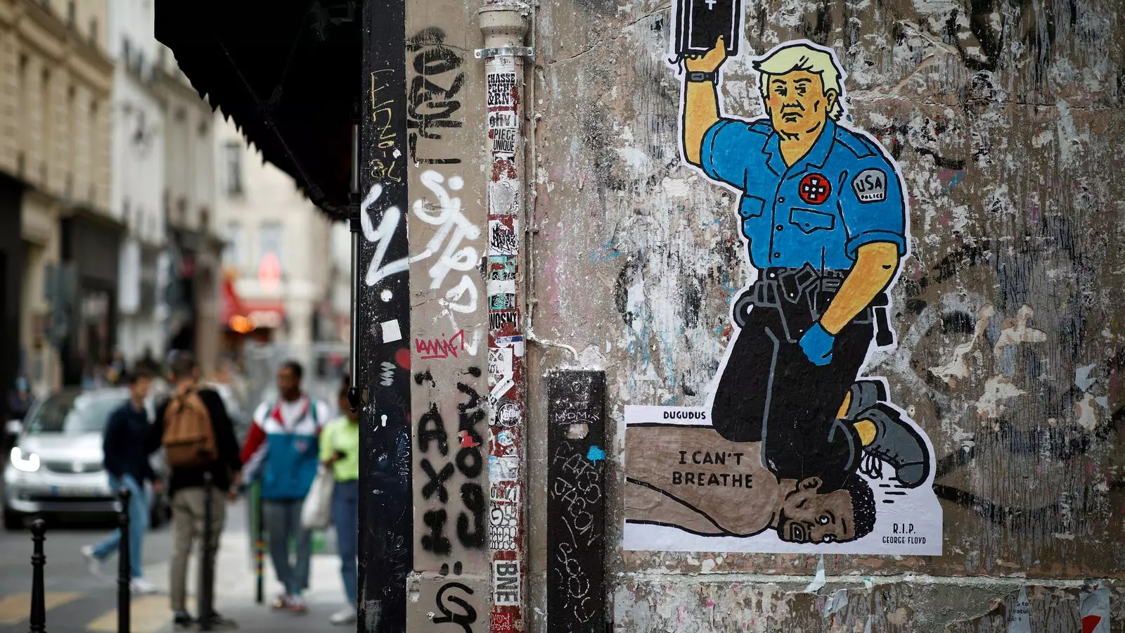 Un grafiti en què un Donald Trump amb uniforme policial i la Bíblia en mà asfixia amb el genoll George Floyd, en un carrer de París