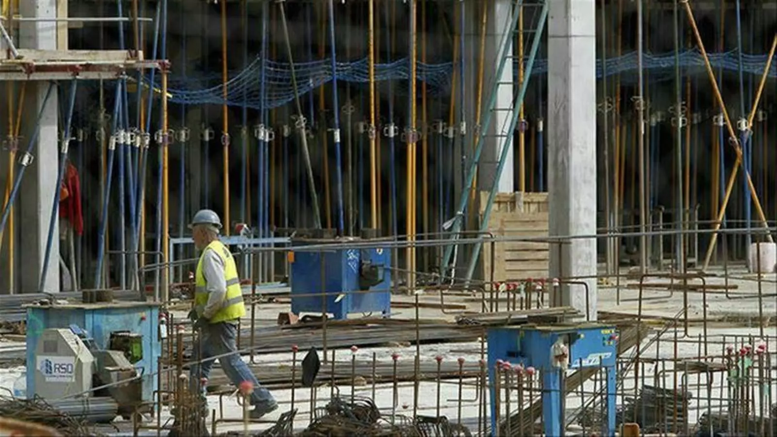 Un home treballant en la construcció d'un edifici.