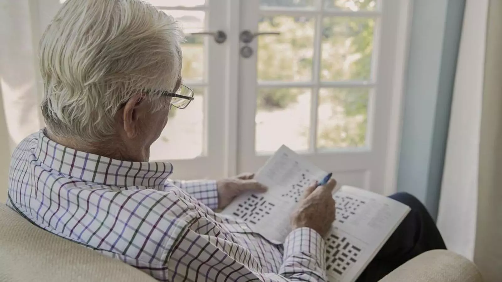 Una persona gran fent sudokus.