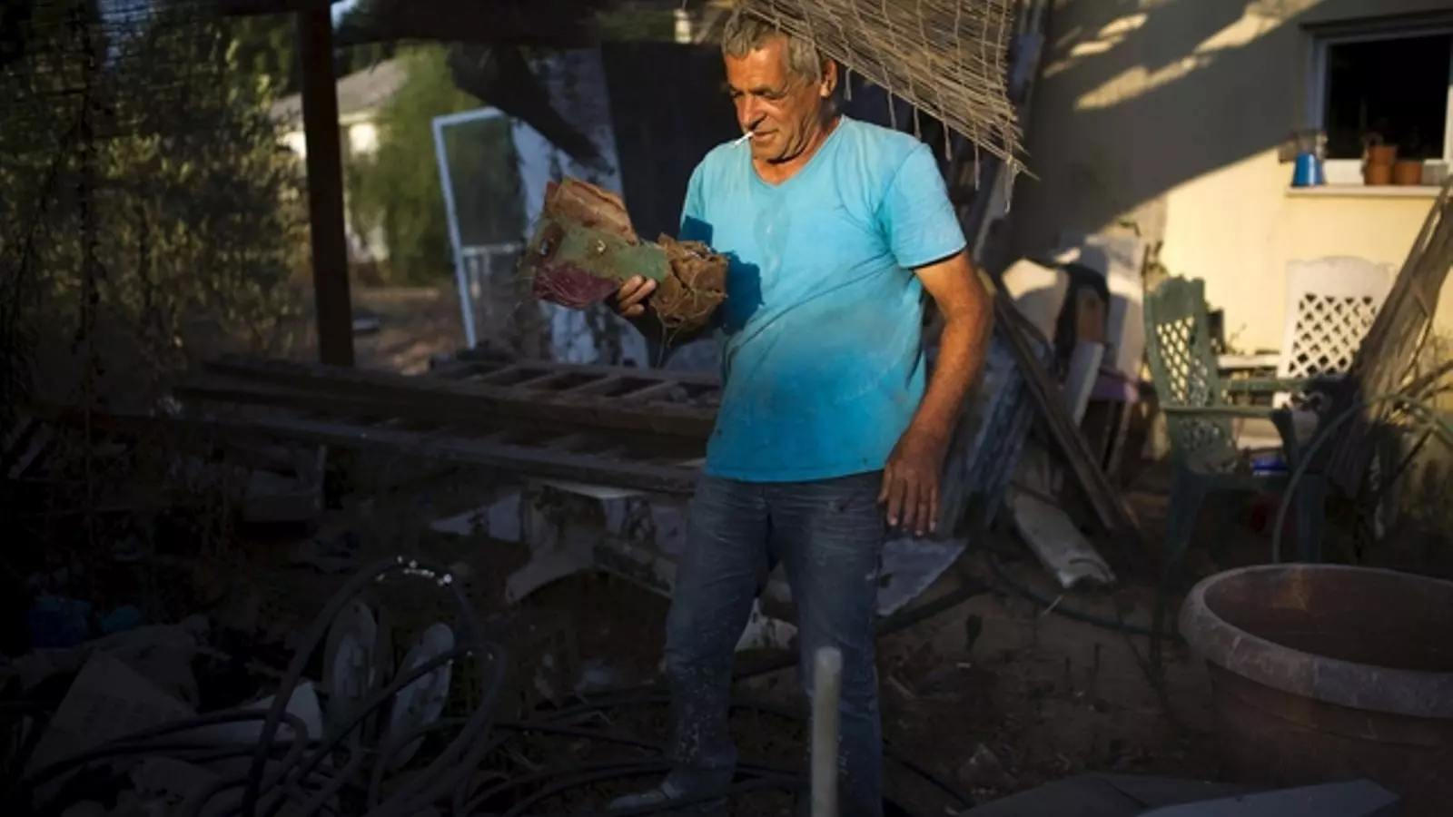 Un ciutadà de la franja de Gaza subjecta les restes d'un projectil que va impactar contra casa seva. AMIR COHEN/REUTERS