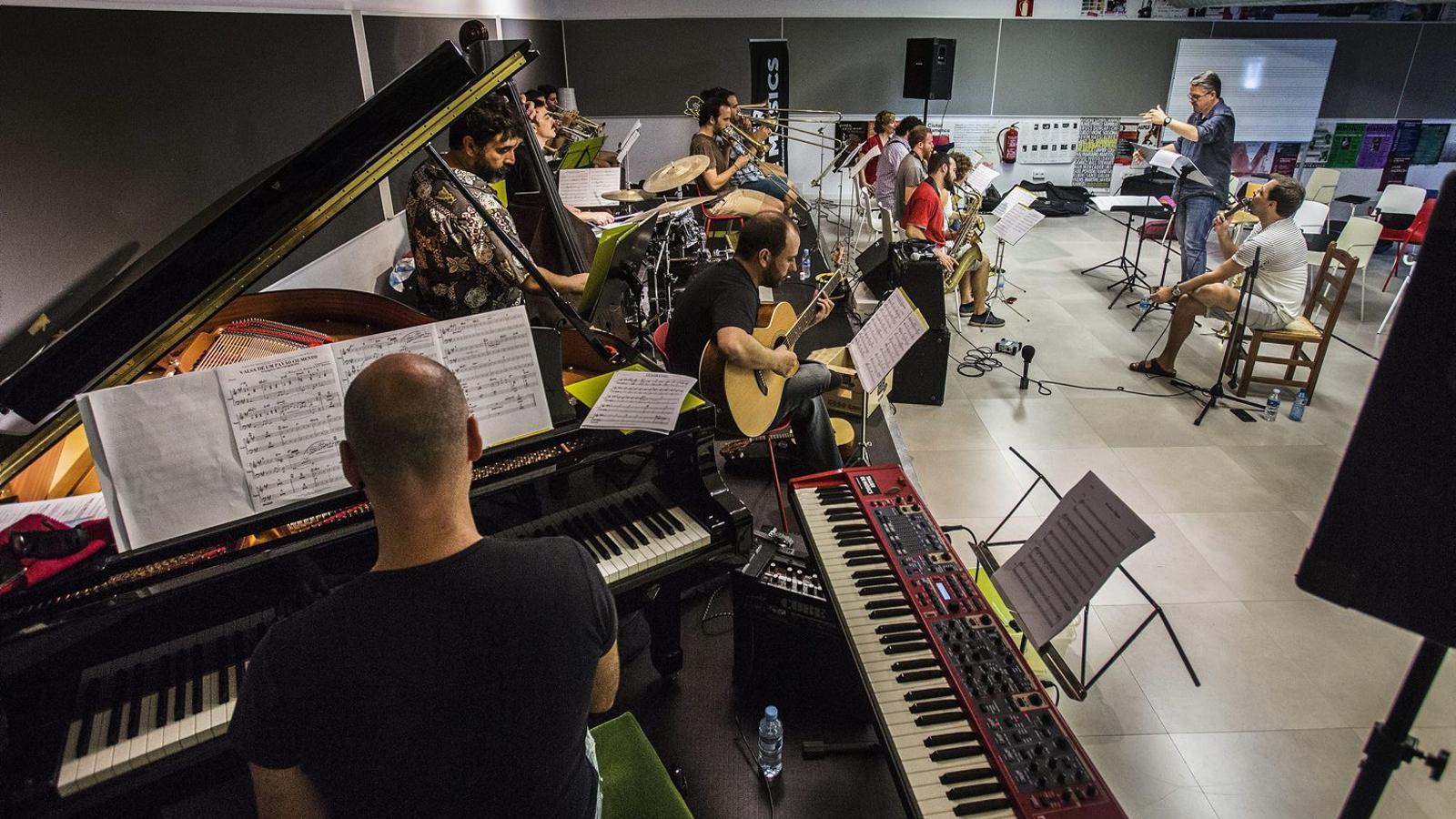 António Zambujo, assegut i amb el micròfon a la mà, durant l’assaig d’ahir al Taller de Músics amb l’Original Jazz Orquestra sota la direcció de David Pastor. Avui estrenen l’espectacle al Mercat de Música Viva de Vic.