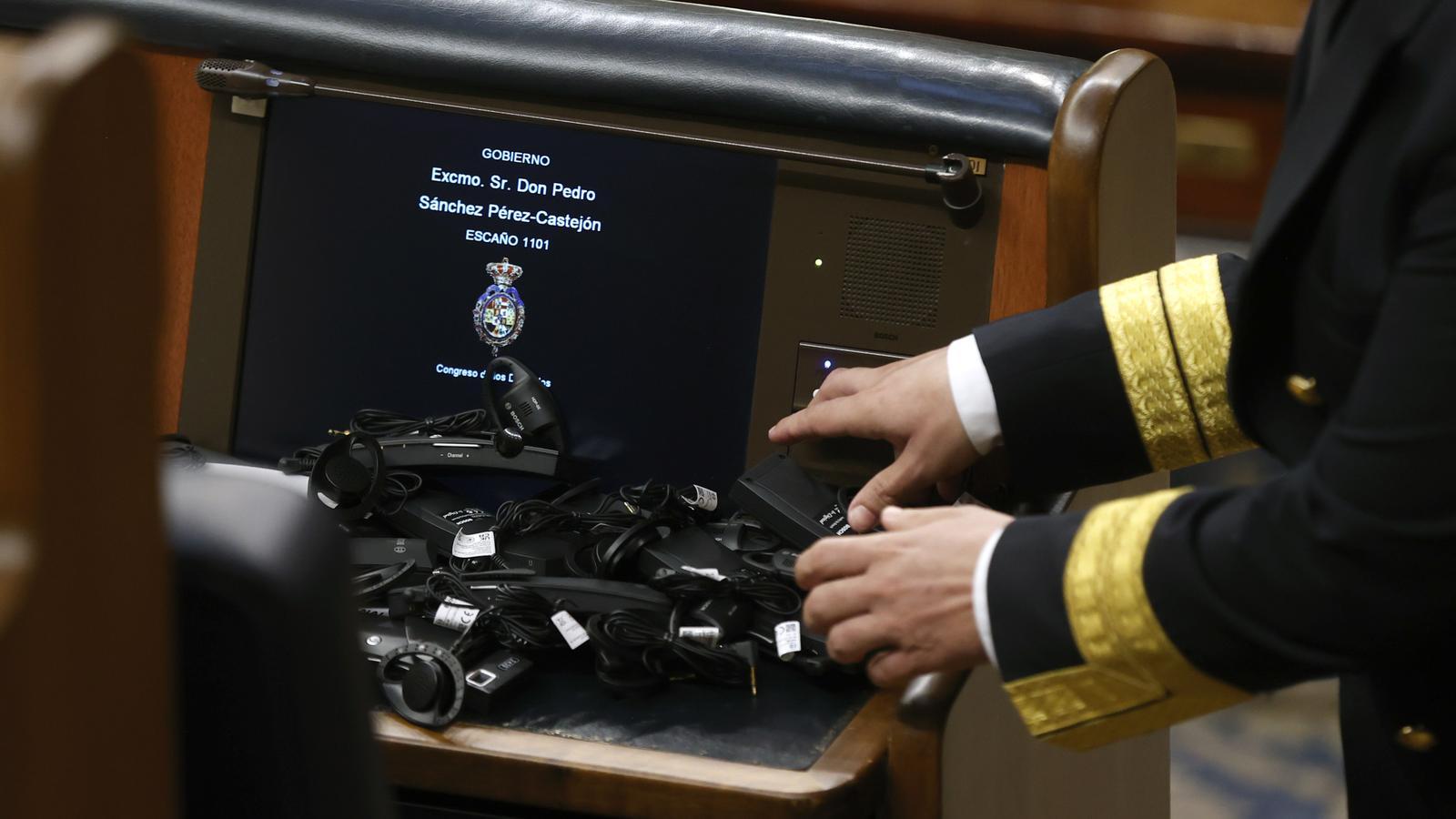A Congress worker collects the pacifiers left by VOX deputies at the beginning of a plenary session in which the use of co-official languages in the Congress of Deputies is approved, on September 19, 2023