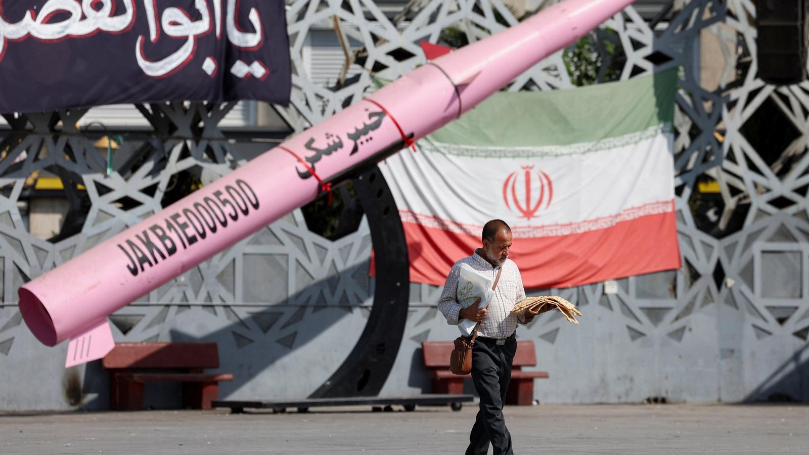 A man walks next to a symbolic model of an Iranian missile in Imam Hussein Square in Tehran.